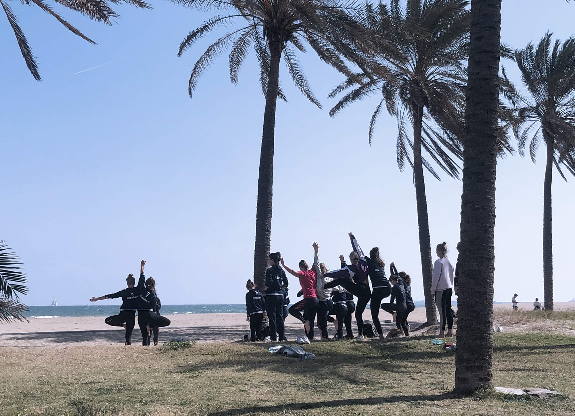 a group of people doing yoga in Valencia by the beach