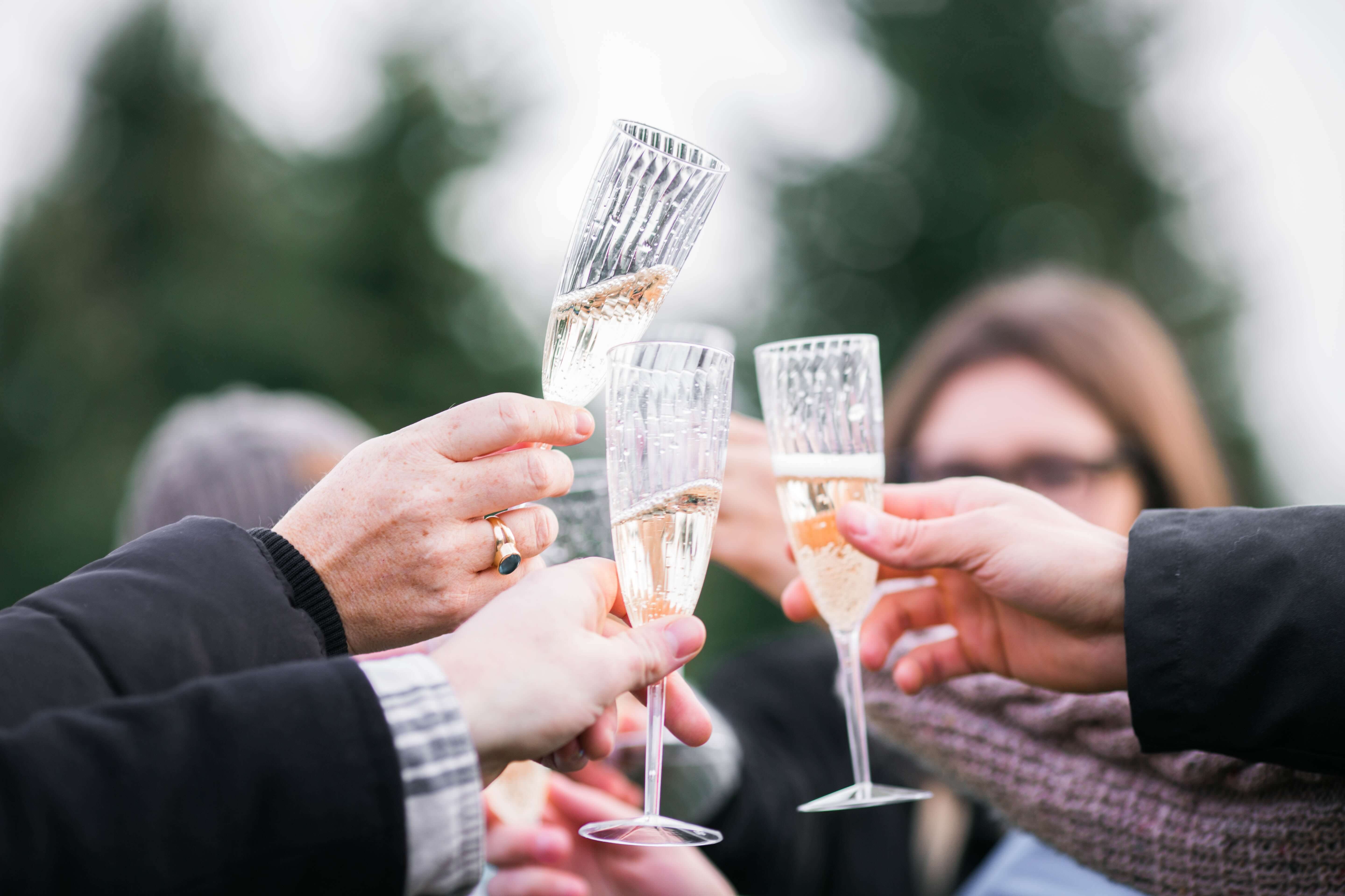 people clinking together cava glasses in the spanish wine region in catalonia