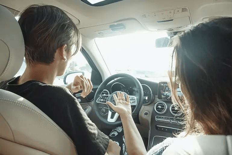 a boy and a girl in a car while the boy is driving