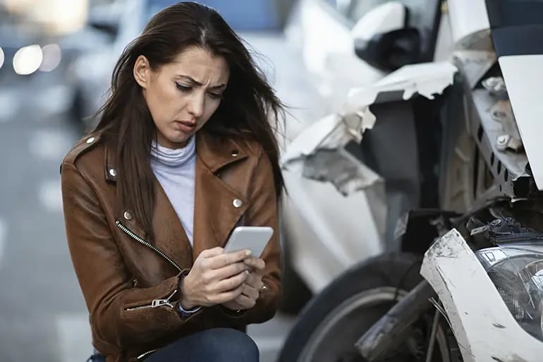 girl calling emergency services after a car accident
