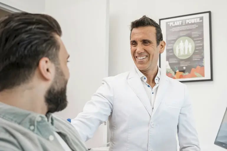 a dentist in a dental clinic smiling at his patient