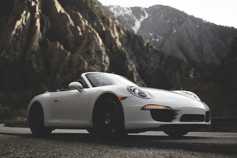 a white sports car in the middle of the mountains