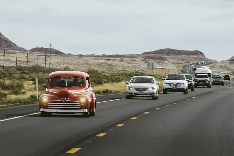 a road with cars of different colours and models driving along it