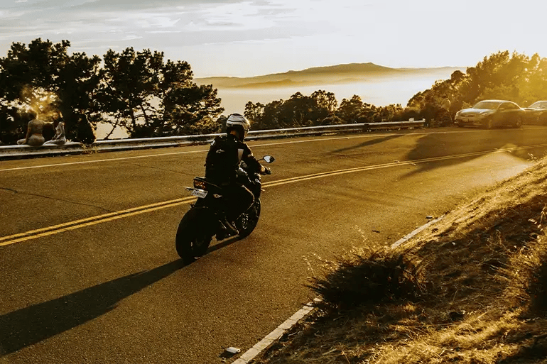 a motorcyclist riding at sunset