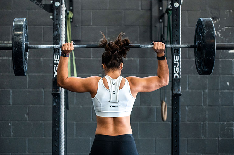 girl at the gym thinking on the best individual health insurance for sports