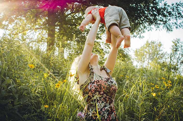 mum lifting child after postpartum appointment 