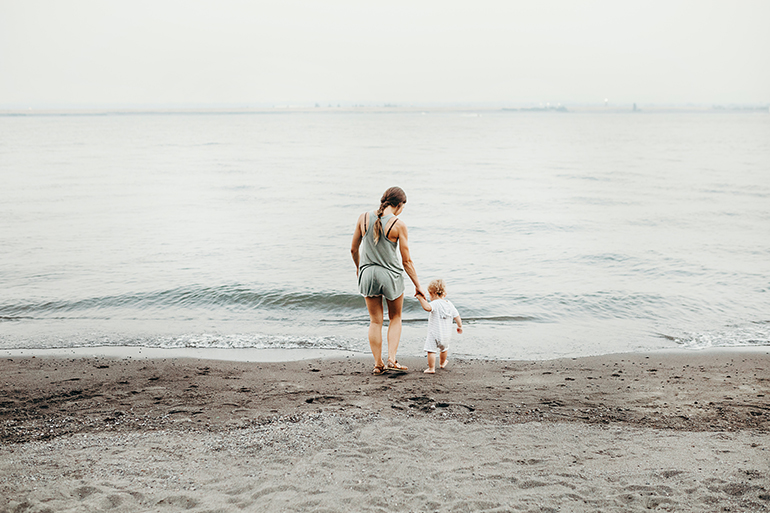 Mum and daughter on the beach using spanish words when pregnant