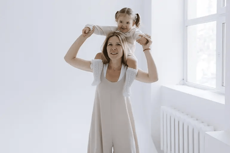 A mother playing with her daughter after getting their life insurance in Spain.