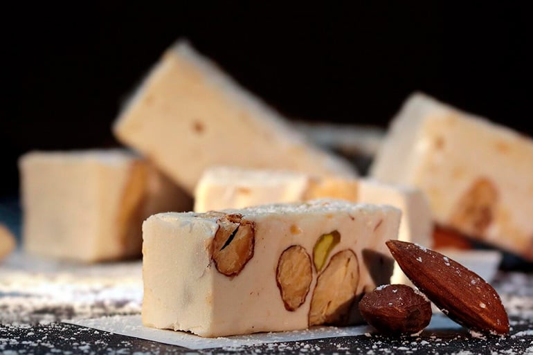 Turrón or toasted almonds and honey are a typical spanish christmas dinner sweets