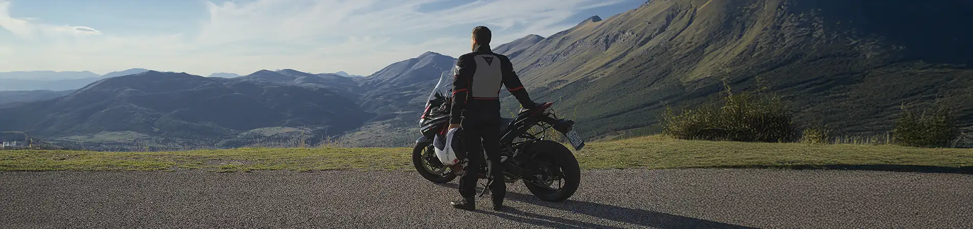 a man with his motorcycle looking the landscape