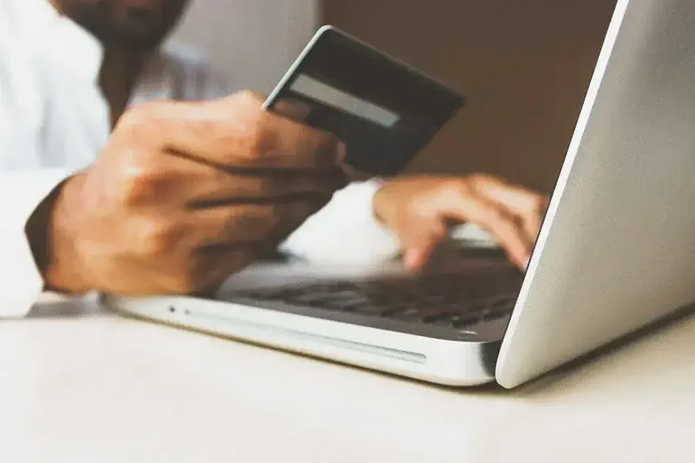 A person paying by card on a computer.