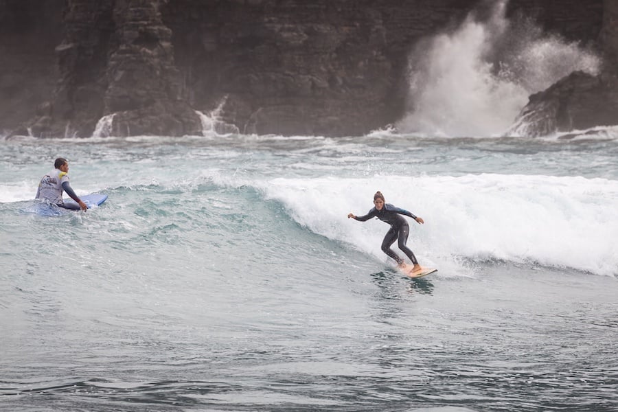 a woman and her partner catching a wave on the top surf spots in spain